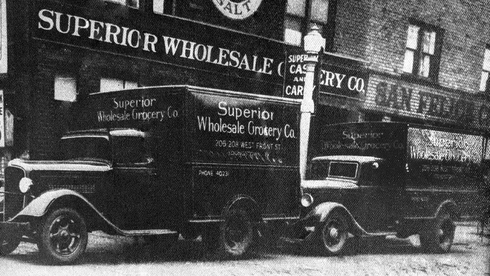 Antique photo of SBG delivery trucks and store front